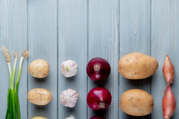 Schließen Sie herauf Ansicht des Musters des Gemüses als Schalottenkartoffel-Knoblauchzwiebel auf hölzernem Hintergrund mit Kopienraum