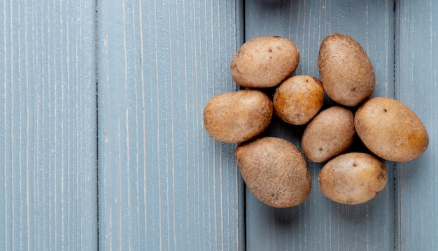 Schließen Sie herauf Ansicht von kleinen Kartoffeln auf der rechten Seite und hölzernem Hintergrund mit Kopienraum