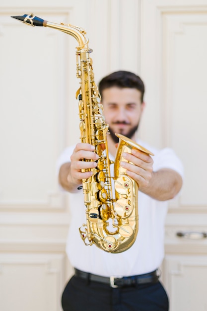 Kostenloses Foto schließen sie herauf das saxophon, das vom musiker gehalten wird