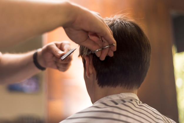 Schließen Sie herauf den hinteren Ansichtmann, der einen Haarschnitt erhält