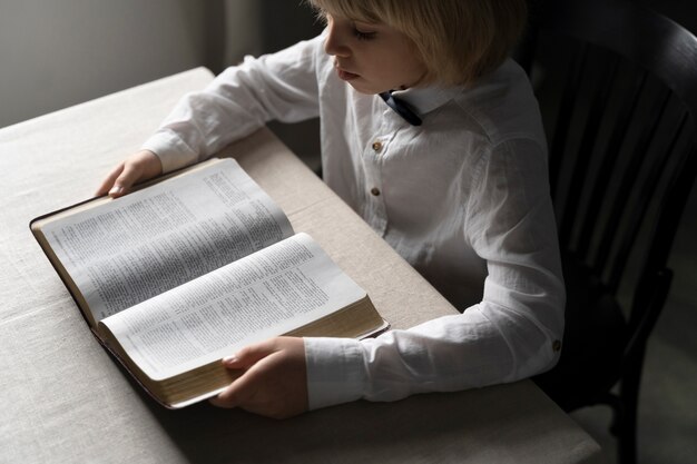 Schließen Sie herauf den kleinen Jungen, der Bibel liest