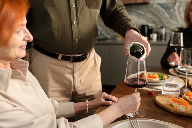 Schließen Sie herauf den Mann, der Getränk im Glas gießt