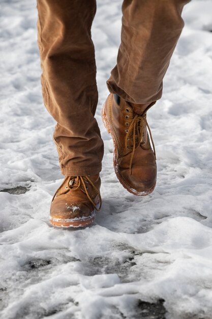 Schließen Sie herauf die Beine, die im Schnee gehen