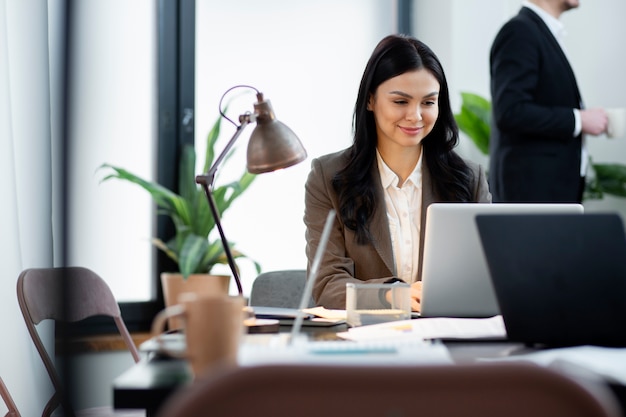 Schließen Sie herauf die Frau, die am Laptop arbeitet