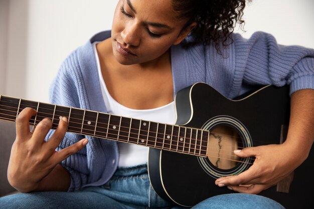 Schließen Sie herauf die Frau, die Gitarre spielt