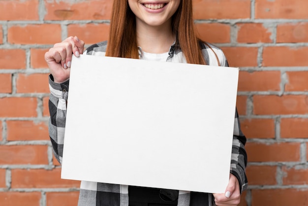 Kostenloses Foto schließen sie herauf die frau, die leeres papier zeigt