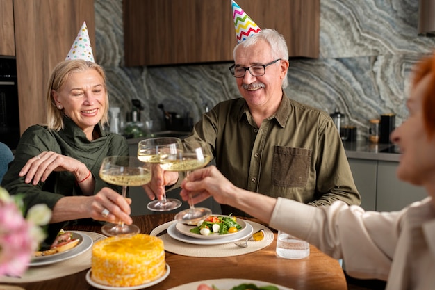 Schließen Sie herauf die glückliche Familie, die Gläser klirrt