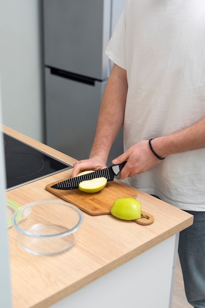 Schließen Sie herauf die Hände, die Apfel mit Messer schneiden