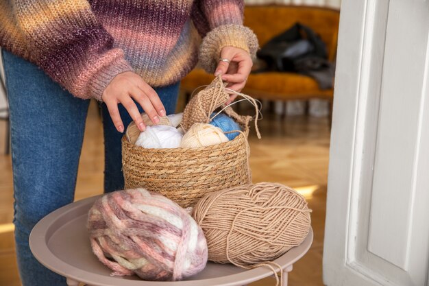 Schließen Sie herauf die Hände, die Garn für das Stricken halten