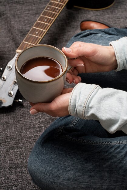 Schließen Sie herauf die Hände, die Kaffeetasse halten