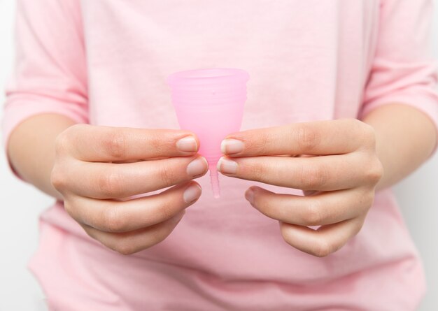 Schließen Sie herauf die Hände, die Menstruationstasse halten