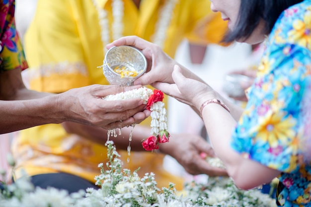 Schließen Sie herauf die Hand, die Blume an der Songkan-Tradition von Thailand hält