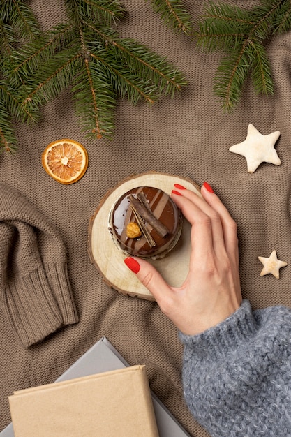 Schließen Sie herauf die Hand, die Schokoladenkuchen hält