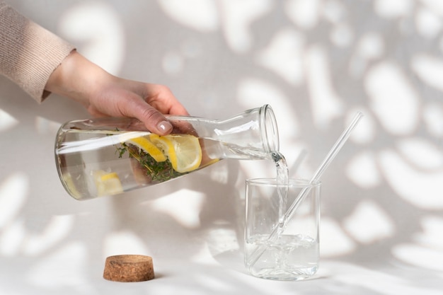 Kostenloses Foto schließen sie herauf die hand, die wasserflasche hält