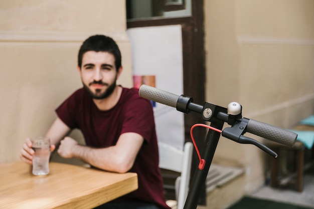 Schließen Sie herauf E-Roller mit defocused Mann