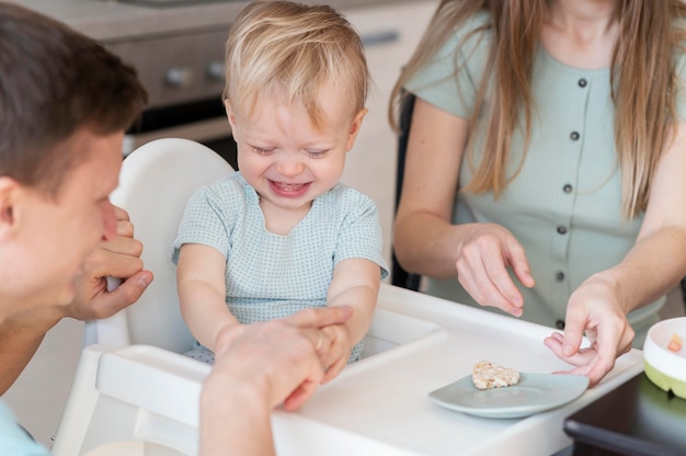 Schließen Sie herauf Eltern, die Kleinkind füttern