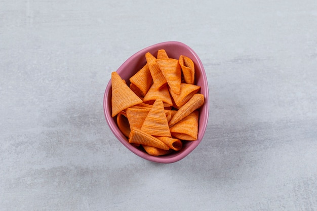 Schließen Sie herauf Foto der würzigen Chips in der lila Schüssel.