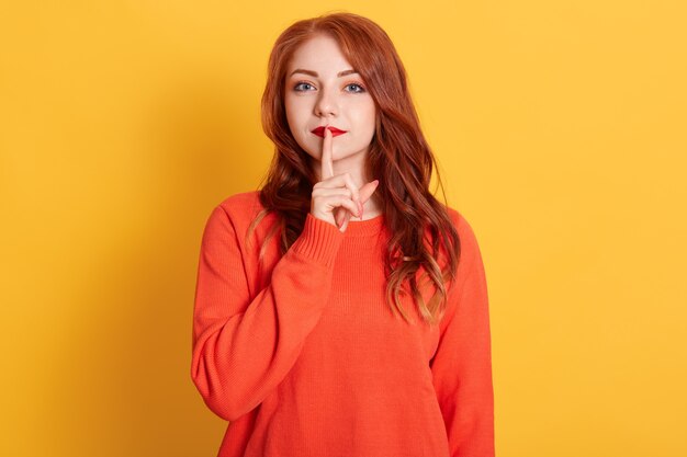 Schließen Sie herauf Foto schöne Dame mit roter Pomade, lange rote Frisur, Zeigefinger nahe Mund halten