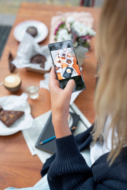 Schließen sie herauf frau, die fotos mit telefon macht