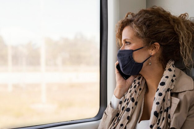 Schließen Sie herauf Frau, die mit Maske reist