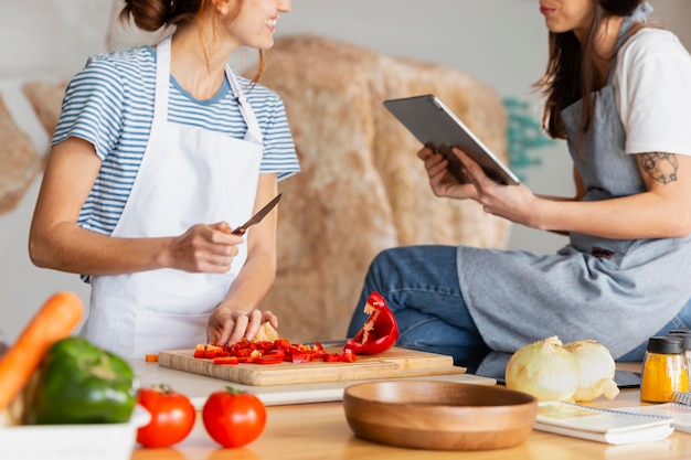 Schließen Sie herauf Frauen mit Tablette in der Küche