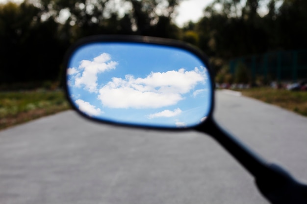 Schließen Sie herauf Himmel im Motorradspiegel