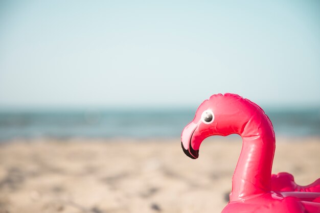 Schließen Sie herauf inflatble Flamingoschwimmring auf Strand