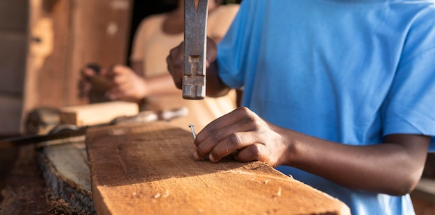 Schließen Sie herauf Kind, das mit Holz arbeitet