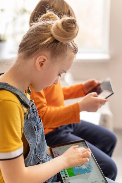 Schließen Sie herauf Kinder, die mit Geräten lernen