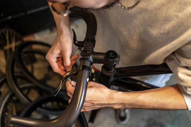 Schließen Sie herauf Mann, der Fahrrad am Laden repariert