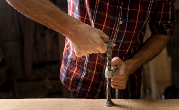 Schließen Sie herauf Mann, der mit Holz arbeitet