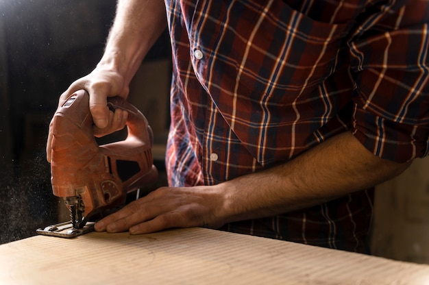 Schließen Sie herauf Mann, der mit Holz arbeitet