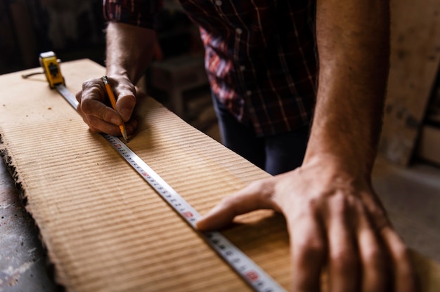 Schließen Sie herauf Mann, der mit Holz arbeitet