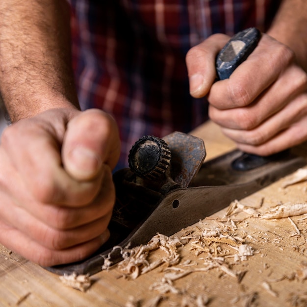 Schließen Sie herauf Mann, der mit Holz arbeitet