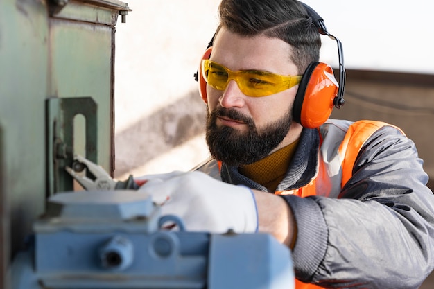 Kostenloses Foto schließen sie herauf mann, der mit werkzeug arbeitet