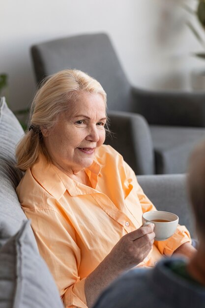 Schließen Sie herauf pensionierte Frau, die Tasse hält