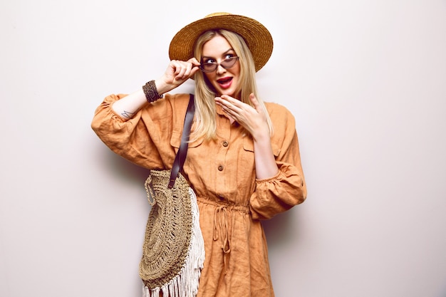 Schließen Sie herauf Porträt der hübschen blonden Frau, die Strohhut und Boho-Outfit trägt