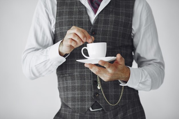 Schließen Sie herauf Porträt des grinsenden altmodischen Mannes. Großvater mit einer Tasse Tee.