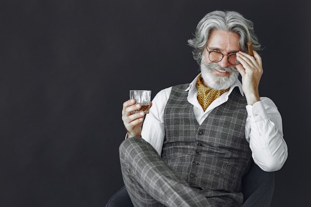 Kostenloses Foto schließen sie herauf porträt des grinsenden altmodischen mannes. großvater mit zigarre und whisky.