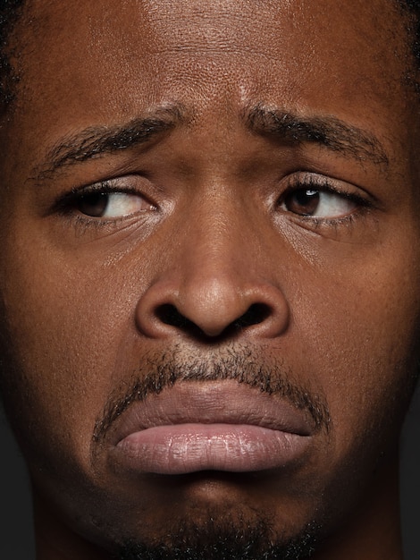Schließen Sie herauf Porträt des jungen und emotionalen afroamerikanischen Mannes
