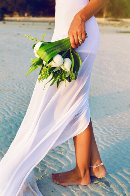 Schließen Sie herauf sinnliches Modebild ow Frau im weißen Kleid, das schönen weißen Lotusstrauß hält.