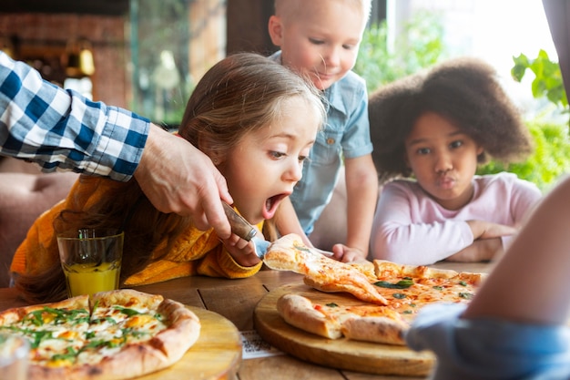 Schließen Sie Kinder mit köstlicher Pizza