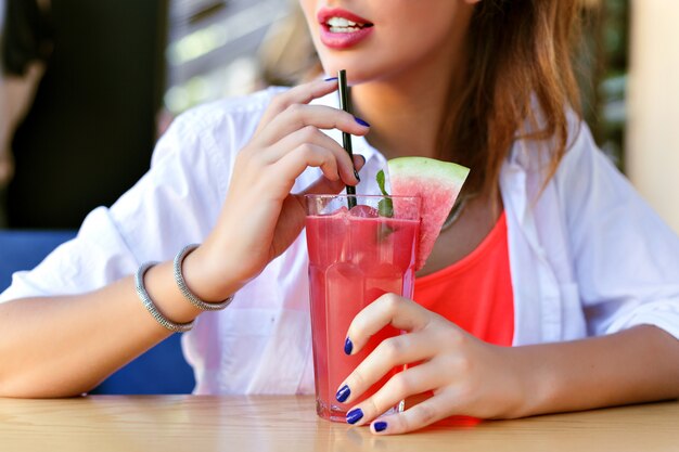 Schließen Sie nahes helles Bild der Frau, die frischen Saft mit Wassermelone, gesunden veganen Lebensstil hält.