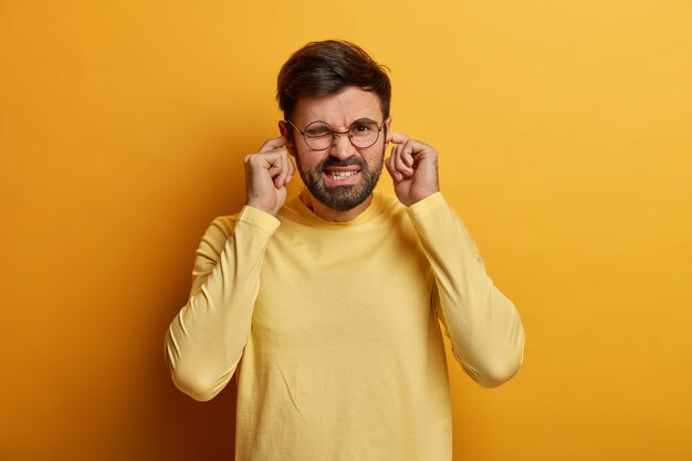 Schließen Sie oben auf bärtigen jungen Mann, der lokalisierte Brille trägt