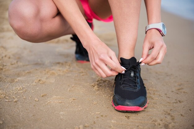 Schließen Sie oben auf junge fit Person, die Schuhlanze bindet