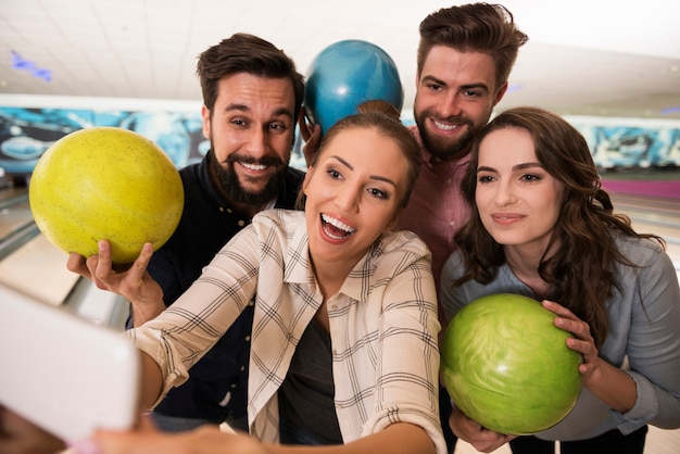 Schließen Sie oben auf junge Freunde, die Bowling genießen