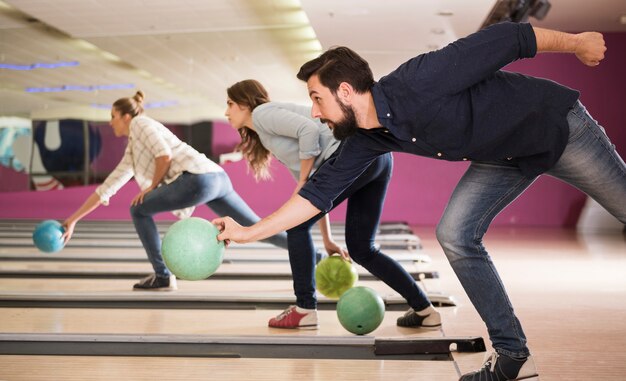 Schließen Sie oben auf junge Freunde, die Bowling genießen