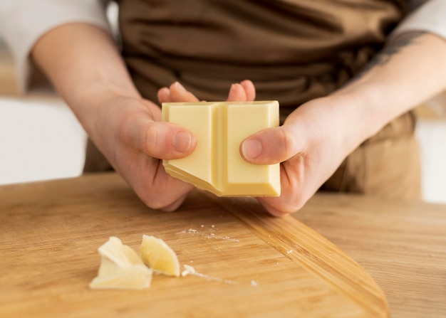 Schließen Sie oben Hände, die Schokolade brechen