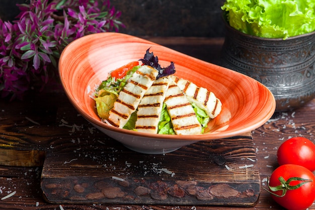 Kostenloses Foto schließen sie oben huhn caesar salat gegrillte hähnchenbrust und frischer salat in teller auf einem dunklen holztisch