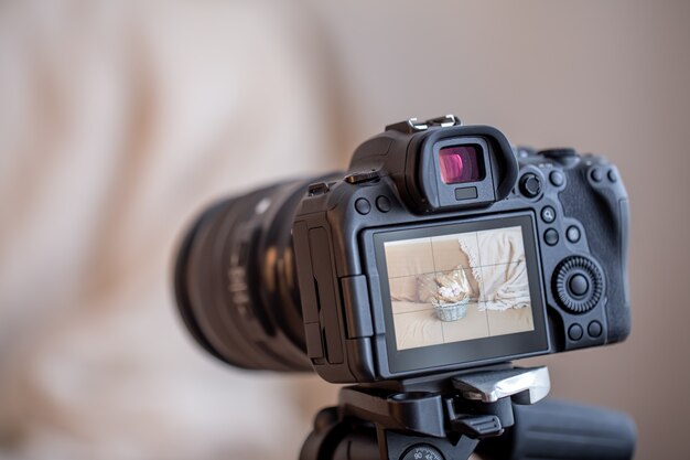 Schließen Sie oben professionelle Digitalkamera auf einem Stativ auf einem unscharfen Hintergrund. Das Konzept der Technologie für die Arbeit mit Fotos und Videos.